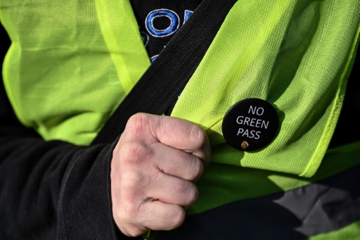 Un docker porte un badge 'No Green Pass' ('Pas de pass sanitaire') lors d'une opération de blocage au port de Gênes, en Italie, le 15 octobre 2021 pour protester contre l'obligation d'avoir un pass sanitaire pour travailler
