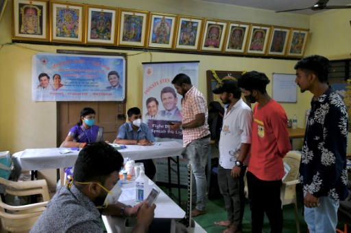 Le personnel de l'hôpital ophtalmologique Narayana Nethralaya aide des volontaires à remplir un formulaire de don des yeux lors d'un événement à la mémoire de l'acteur Puneeth Rajkumar à Bangalore le 18 novembre 2021

